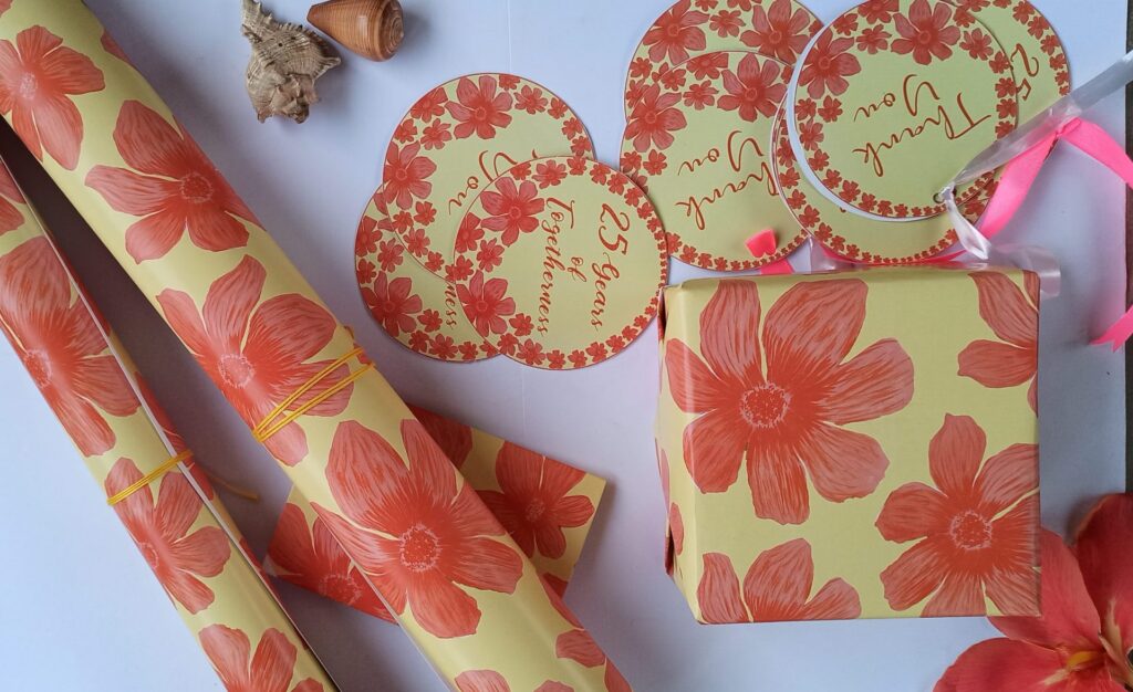 Gifts wrapped in customized paper with "25th Wedding Anniversary" text and elegant silver accents.