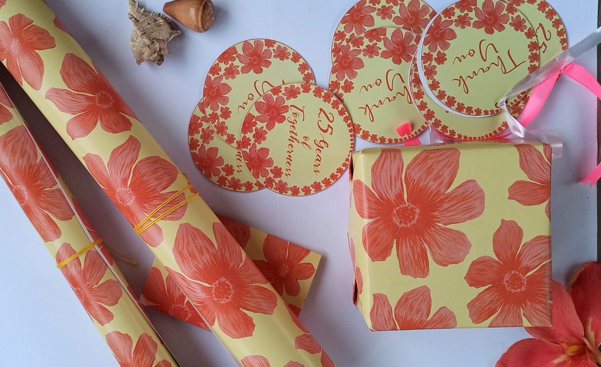 Gifts wrapped in customized paper with "25th Wedding Anniversary" text and elegant silver accents.